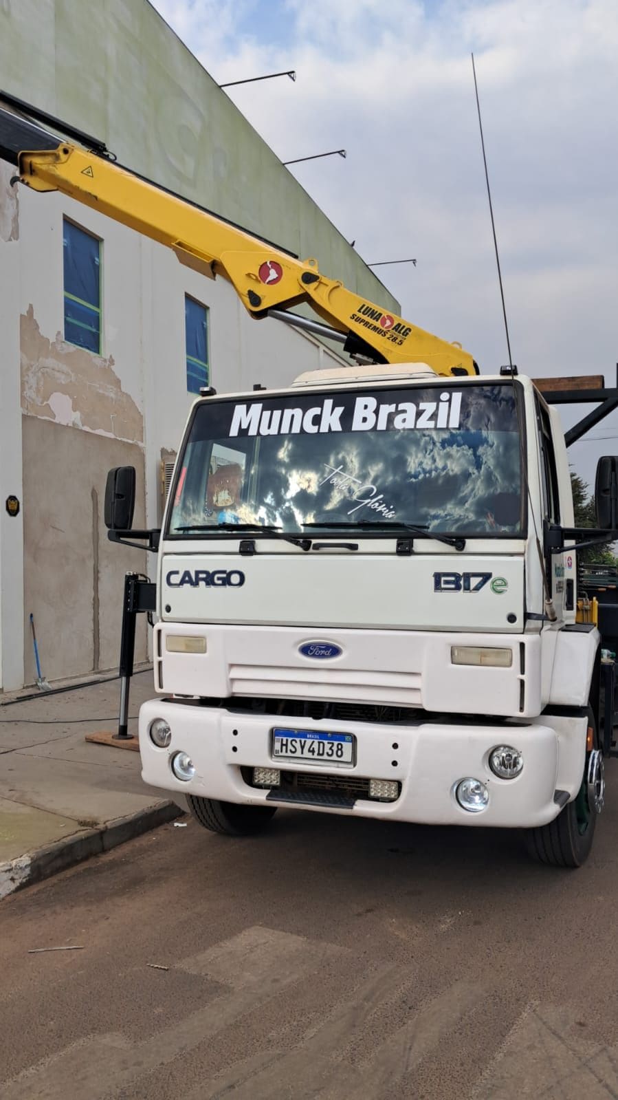 Caminhão Ford Cargo da Munck Brazil com o munck recolhido, em frente a um prédio
